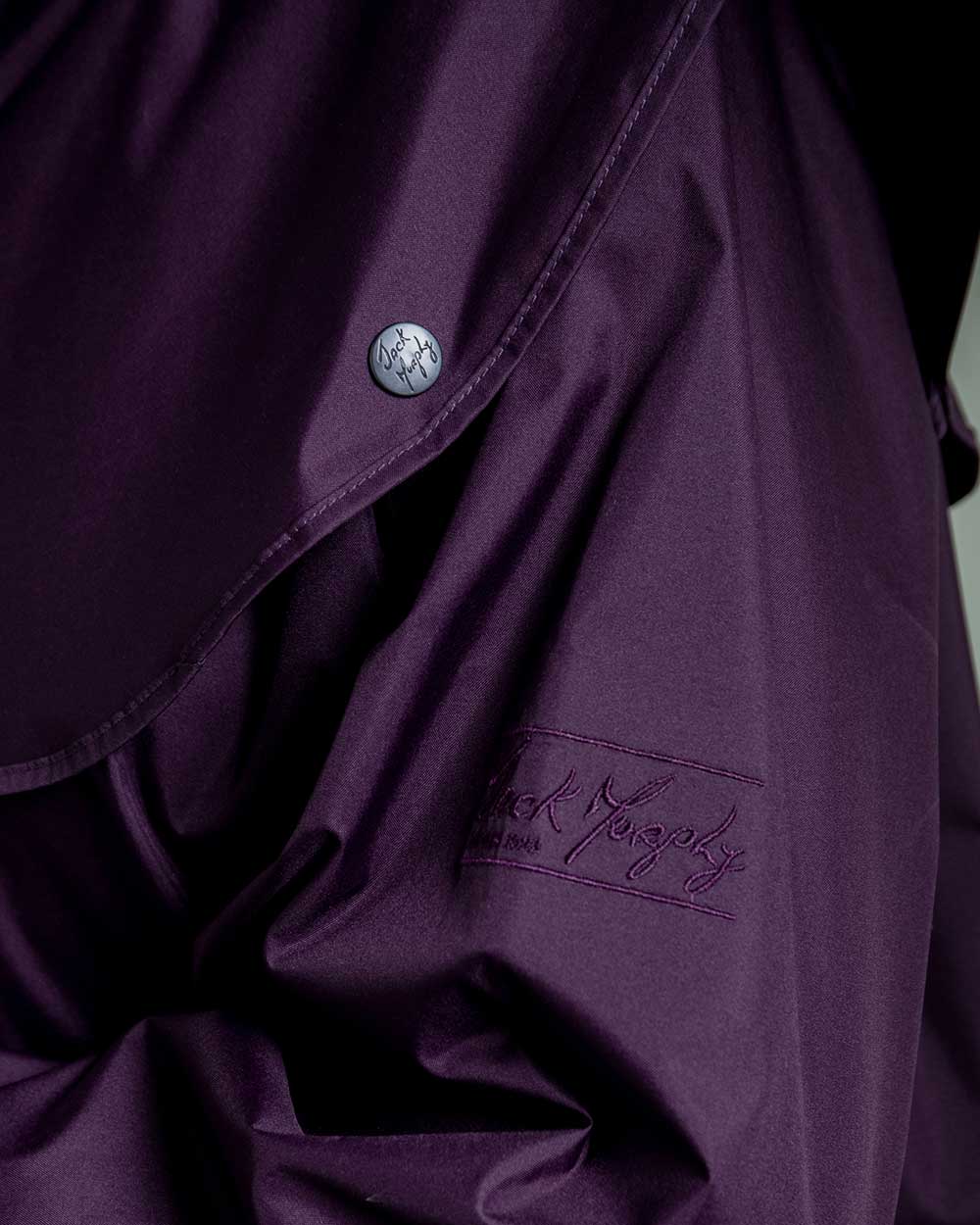Blackberry coloured Jack Murphy Malvern Ladies Waterproof Bush Coat on wall background