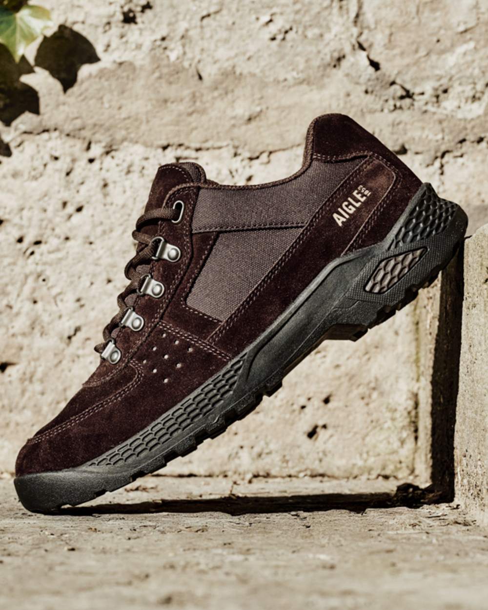 Brown coloured Aigle Mens Dolik Hiking Shoes on stone background