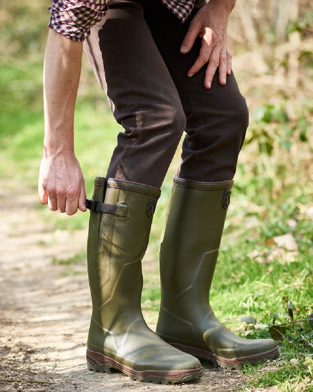 Kaki coloured Aigle Parcours 2 Vario Wellington Boots on forest background