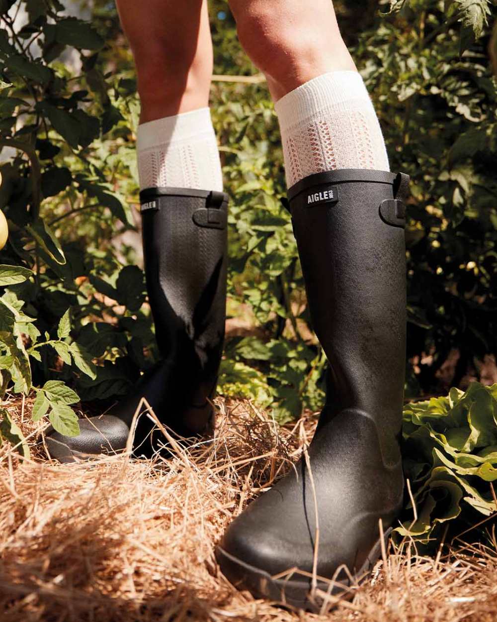 Black coloured Aigle Womens Alya High Leisure Boots on forest background