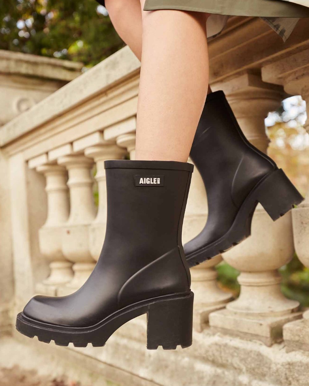 Noir coloured Aigle Womens Monceau Heeled Ankle Boots on outdoor background