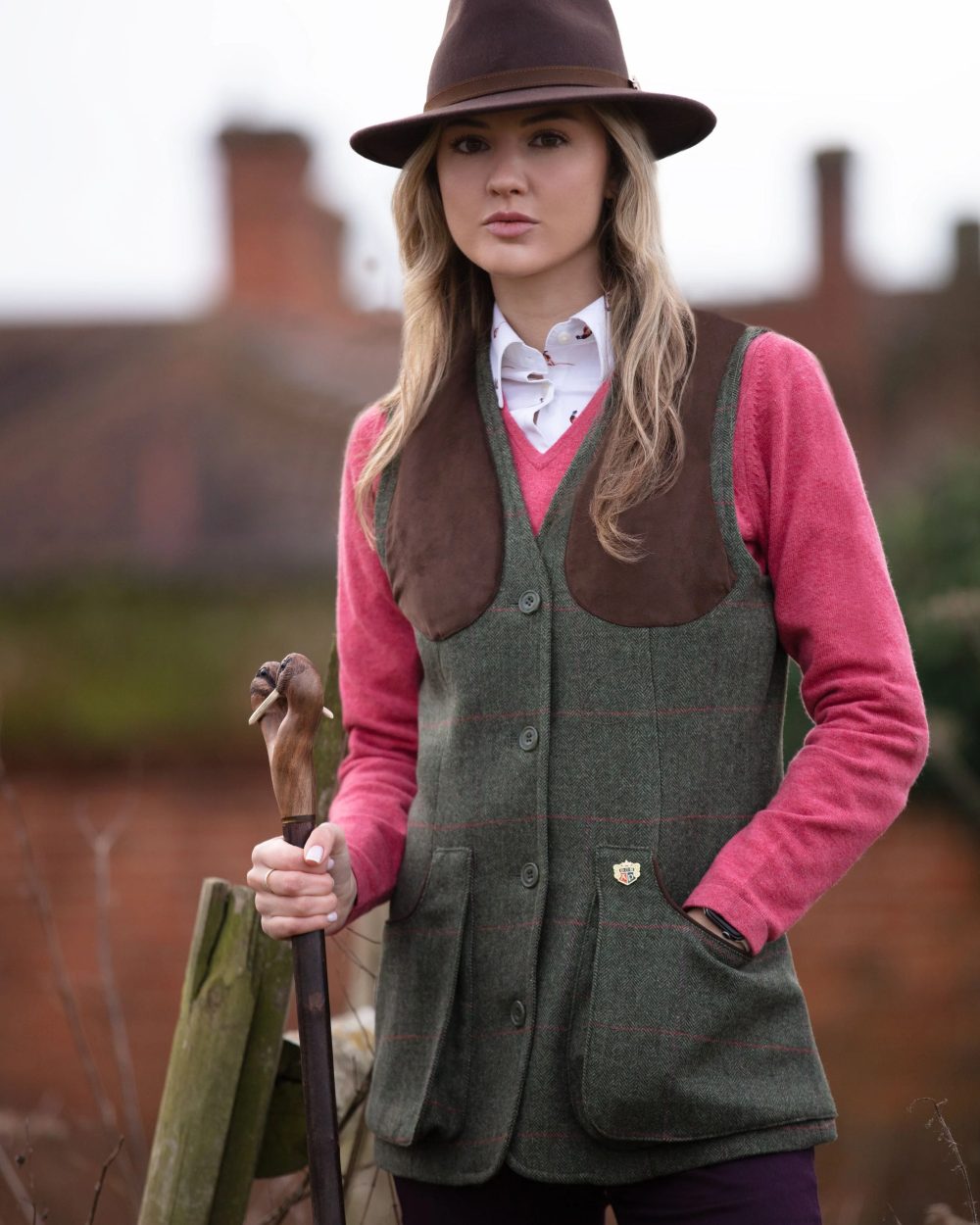 Heath coloured Alan Paine Combrook Ladies Tweed Shooting Waistcoat on blurry background