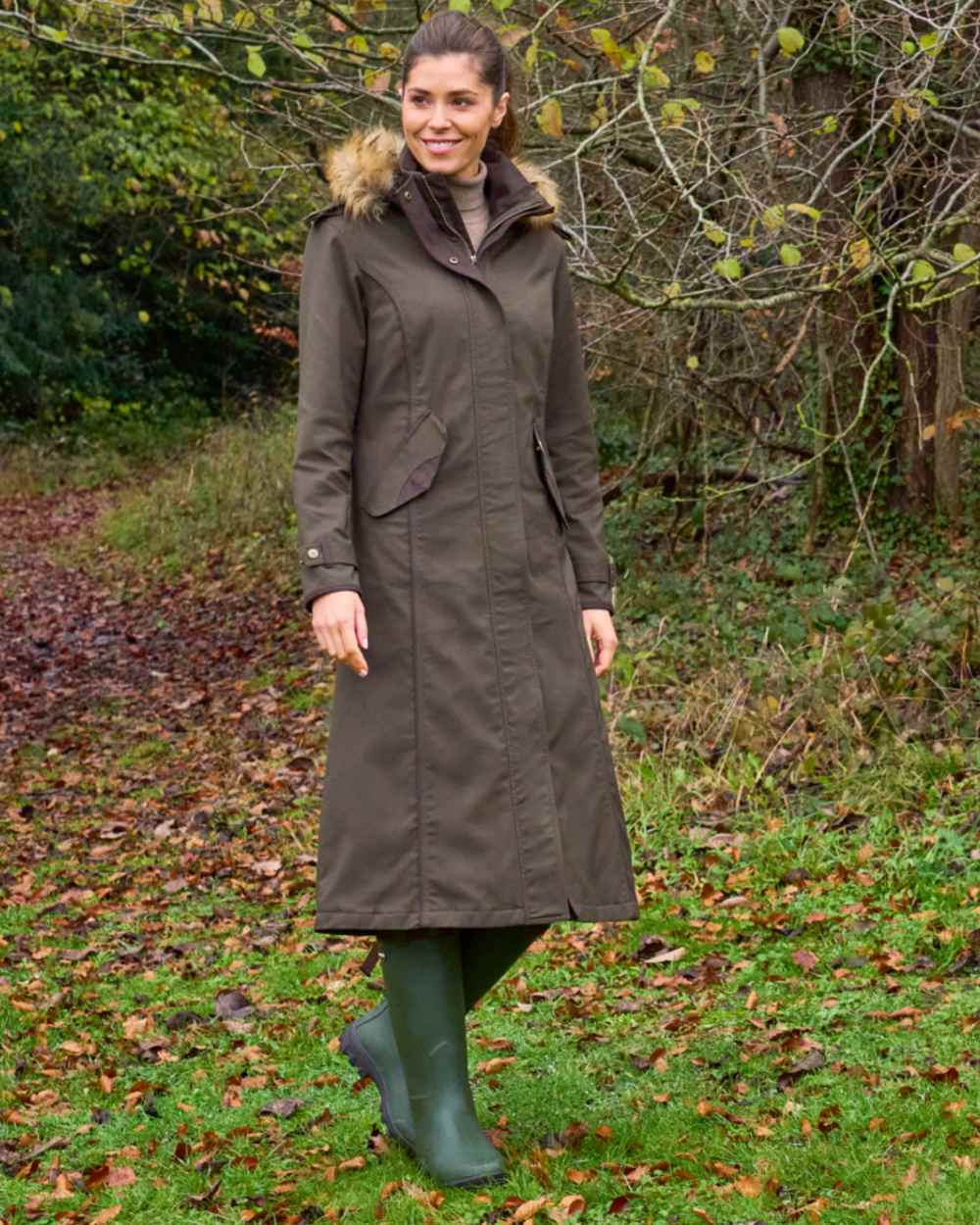 Olive coloured Alan Paine Ladies Dunswell Waterproof Long Coat on forest background
