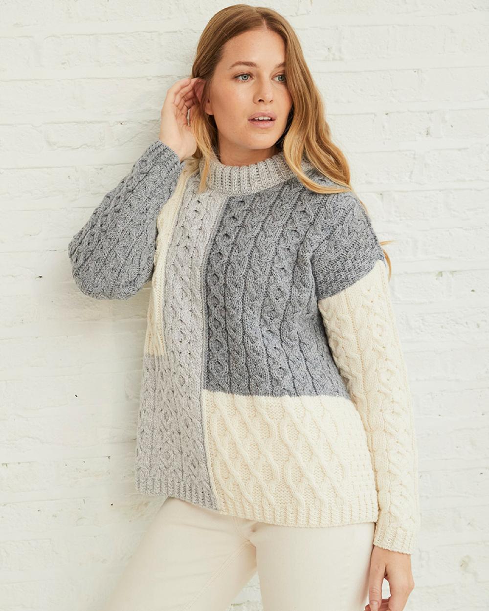 Dawn Coloured Aran Cobh Sweater on grey wall background