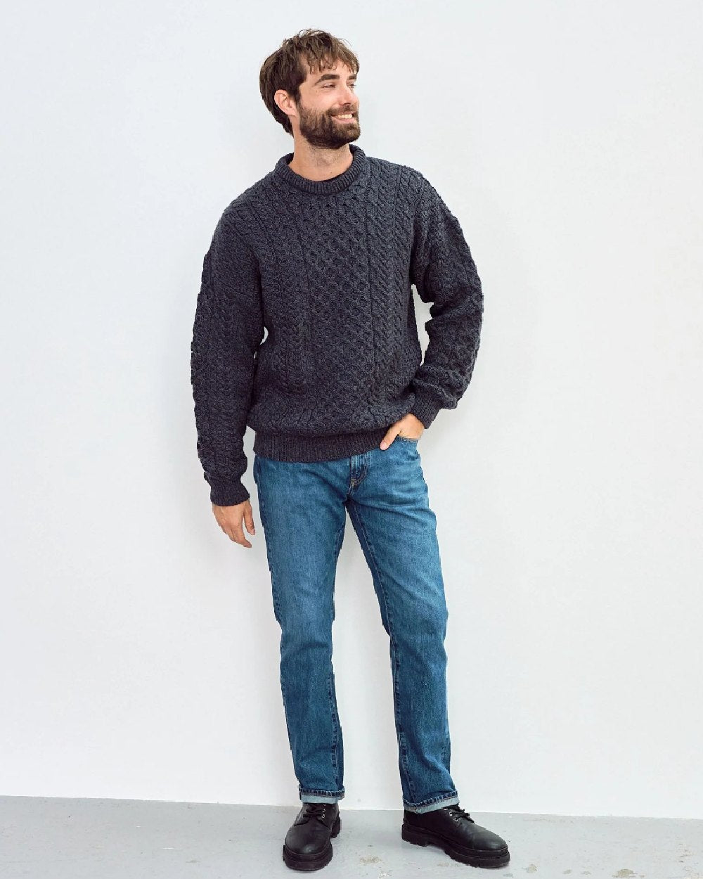 Charcoal Coloured Aran Inisheer Traditional Sweater on grey wall background