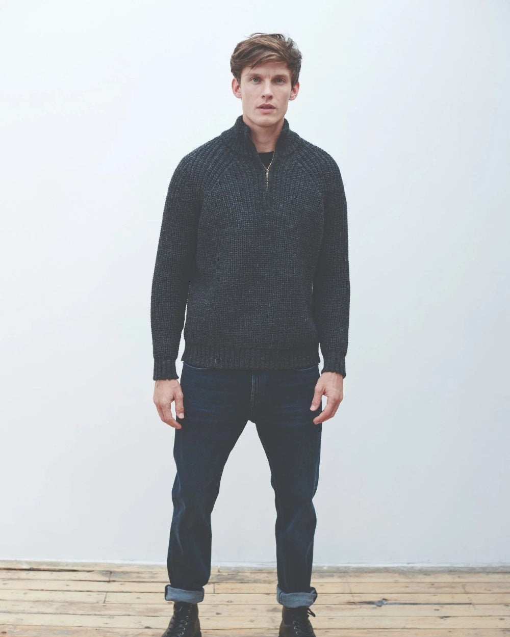 Grey coloured Aran Mens Fisherman Raglan Zip Sweater on grey wall background