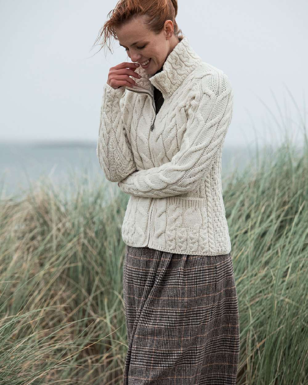 Cream Coloured Aran Merino Wool Full Zip Cardigan on grass background