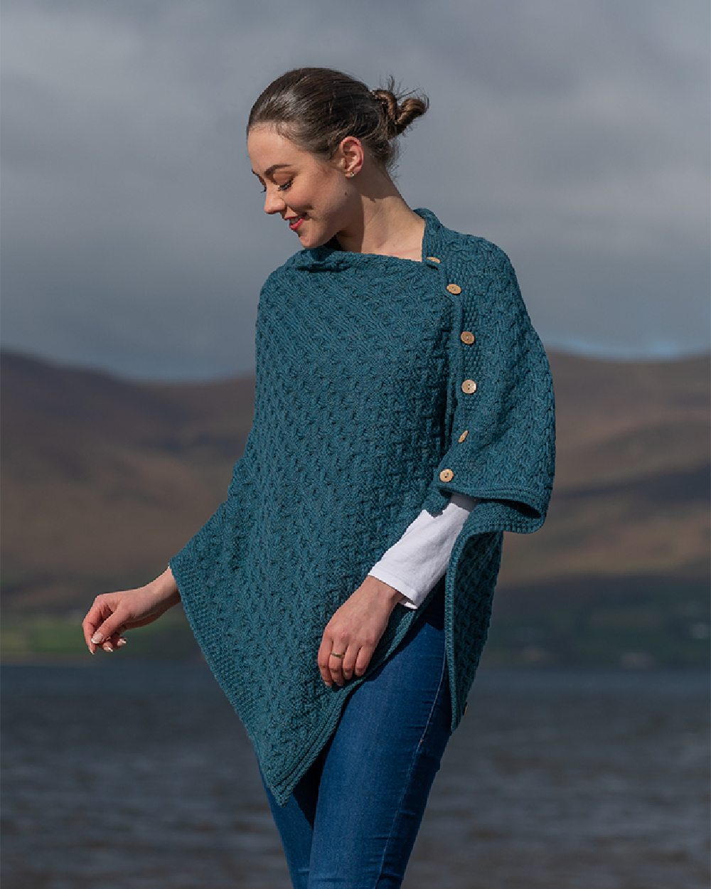 Teal Coloured Aran Merino Wool Knit Button Poncho on lake background