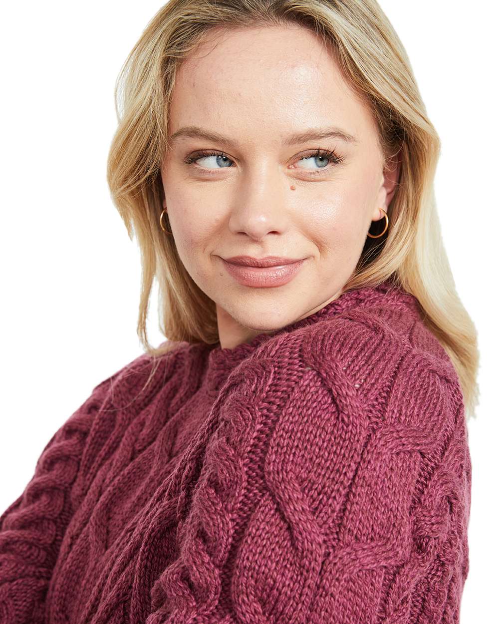 Raspberry Coloured Aran Womens Listowel Cabled Sweater on curtain background
