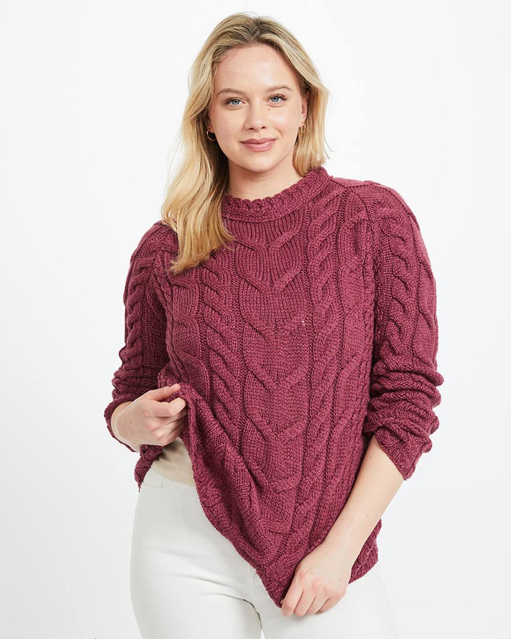 Raspberry Coloured Aran Womens Listowel Cabled Sweater on curtain background