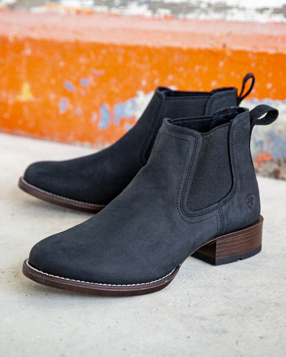 Den Black Coloured Ariat Mens Booker Ultra Round Toe Western Boot on wall background