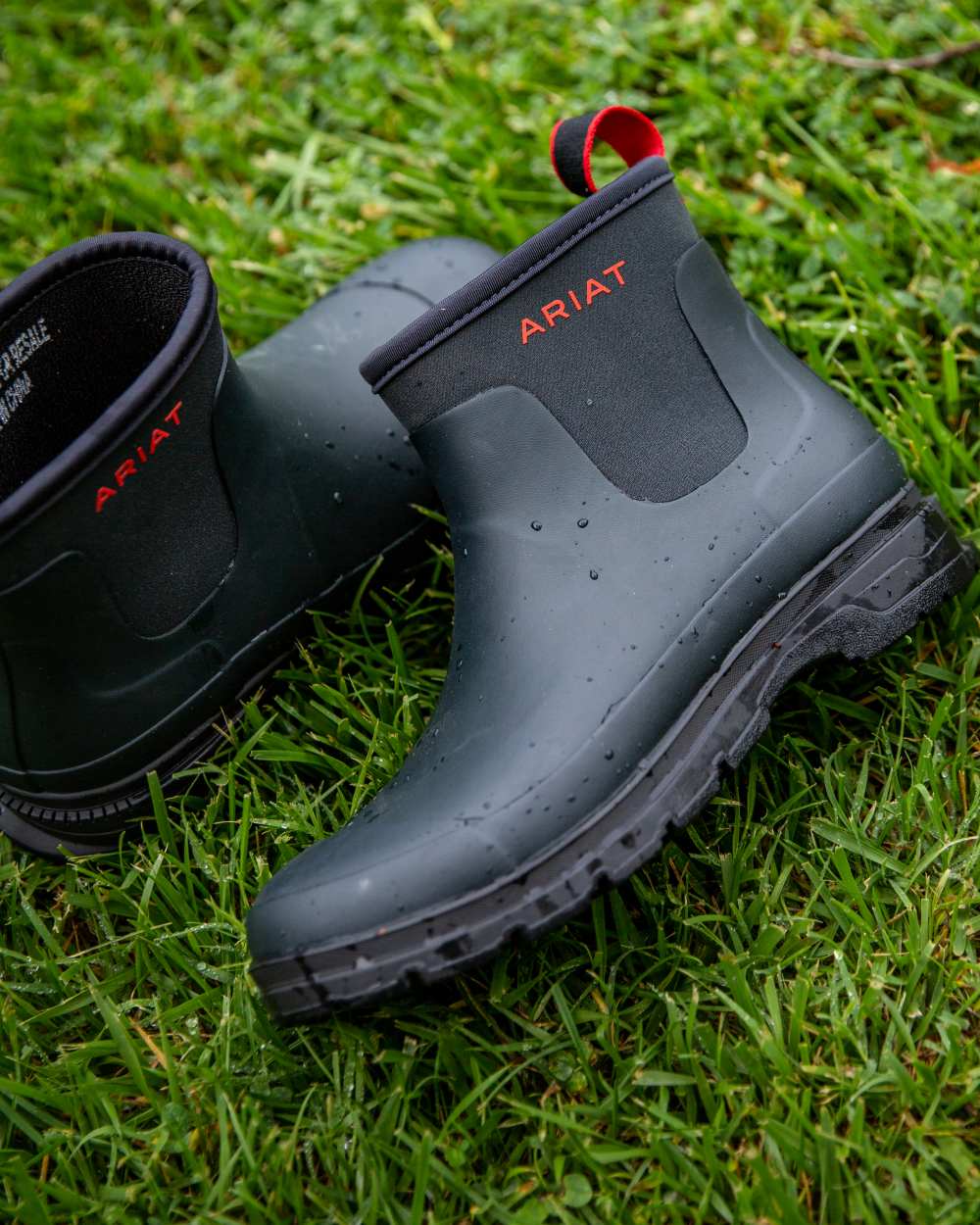 Navy coloured Ariat Womens Kelmarsh Shortie Rubber Boots on grass background