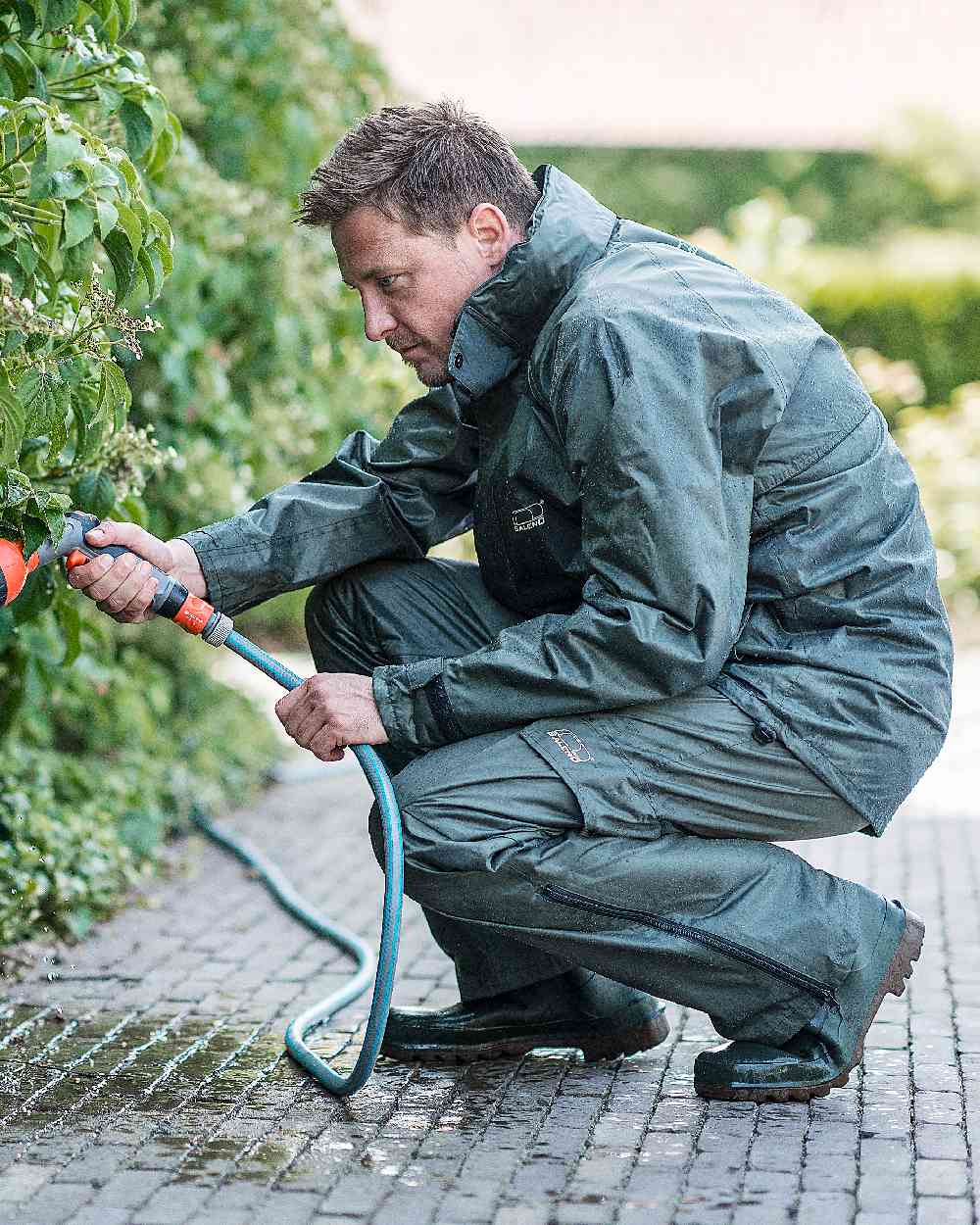 Khaki Coloured Baleno Dolomit Rain Jacket on garden background
