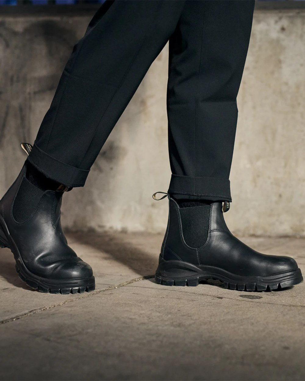 Black coloured Blundstone 2240 Black Leather Chelsea Boots on wall background