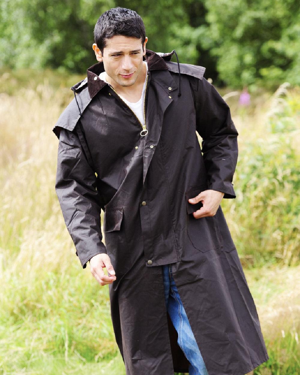 Brown coloured Bronte Long Wax Cotton Coat on grass background