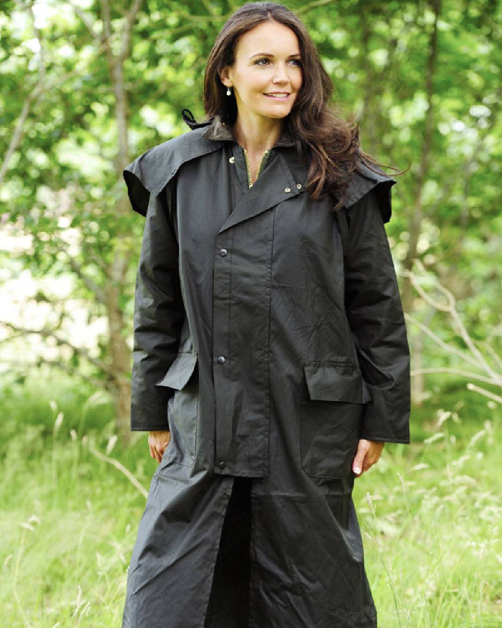 Green coloured Bronte Long Wax Cotton Coat on grass background
