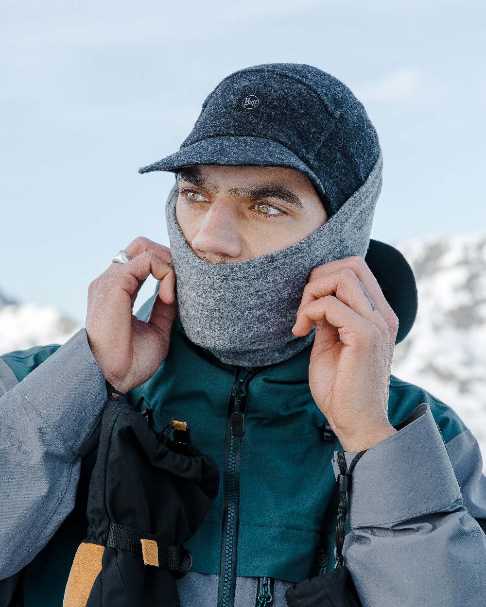 Grey Coloured Buff Merino Fleece Neck Warmer on snow background