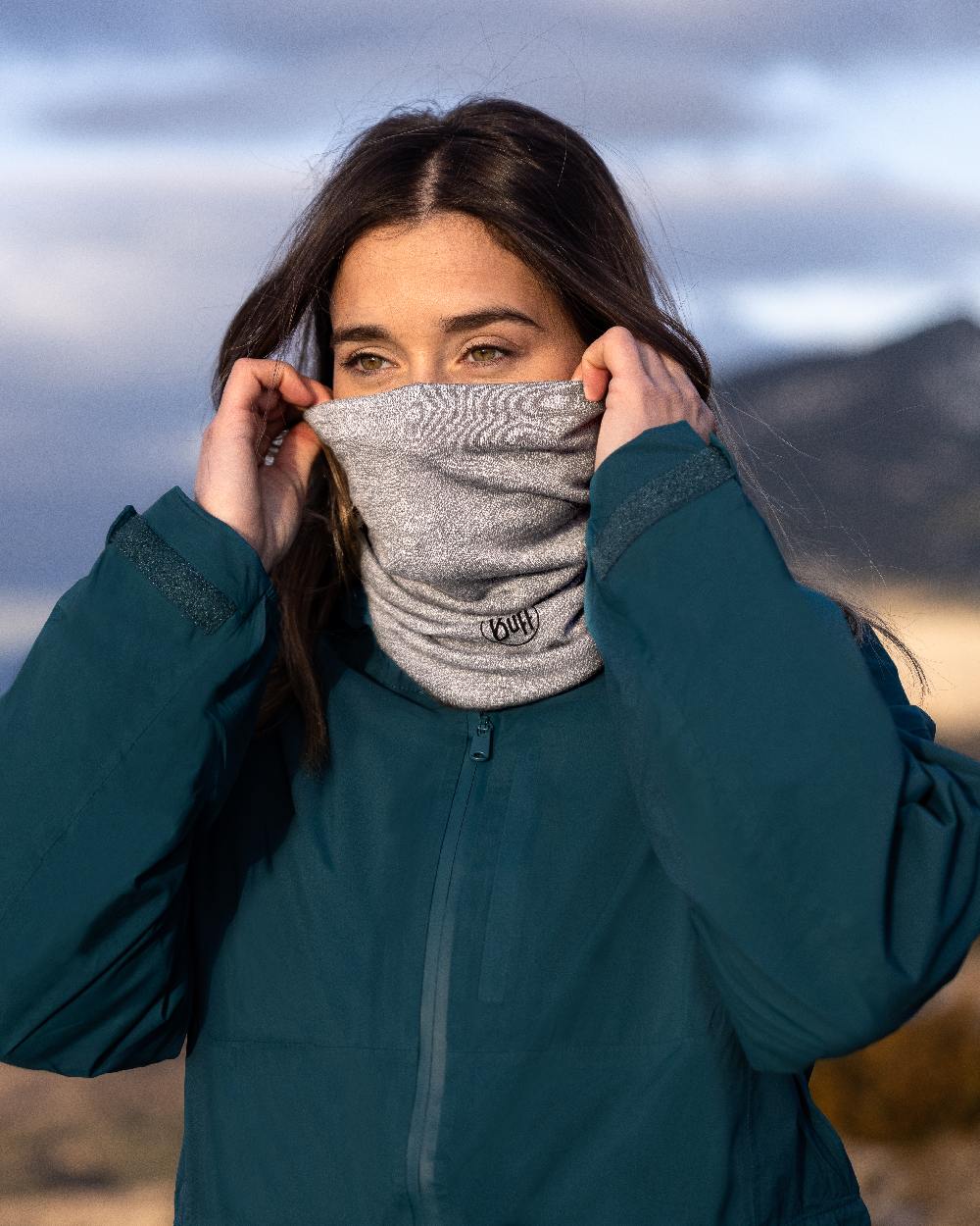 Light Grey Coloured Buff Merino Lightweight Neck Warmer on blurry background