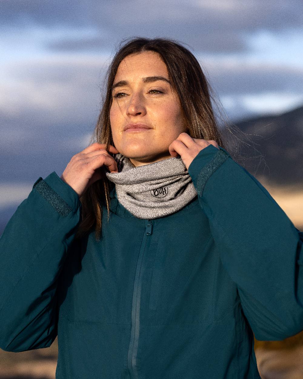 Light Grey Coloured Buff Merino Lightweight Neck Warmer on blurry background