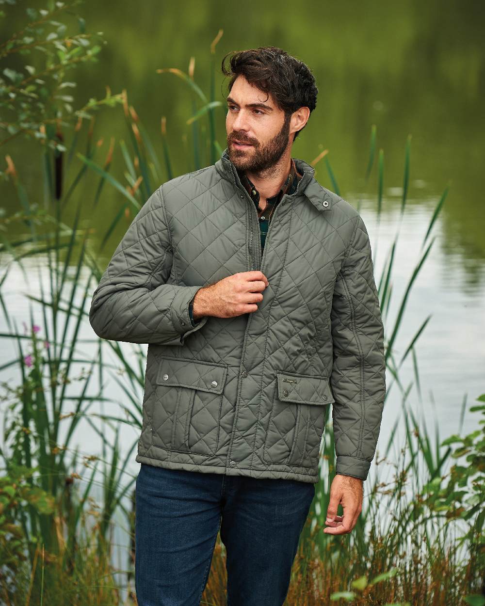 Olive coloured Champion Padstow Quilted Jacket on pond background