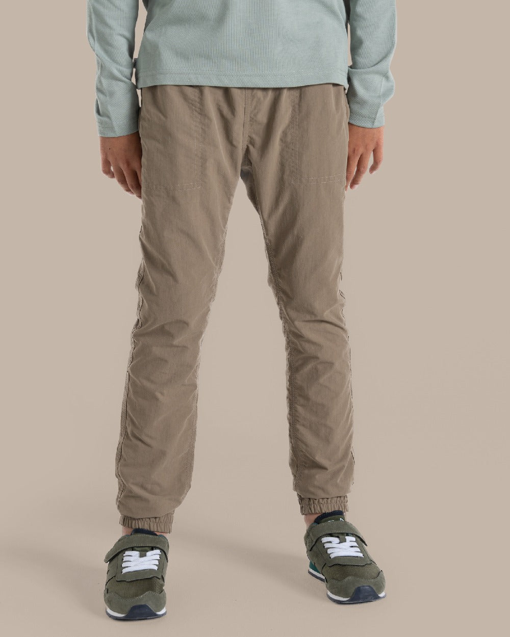 Pebble Coloured Craghoppers Kids Nosilife Pinzon Trousers on Beige Background