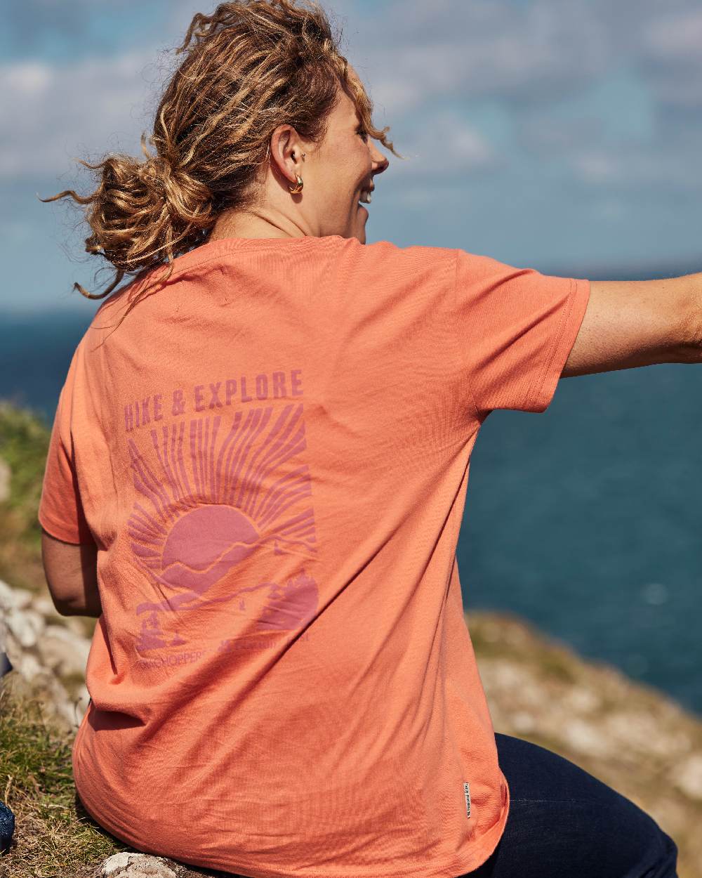 Red Sandstone coloured Craghoppers Womens National Trust Bistort Short Sleeved T-Shirt on coastal background