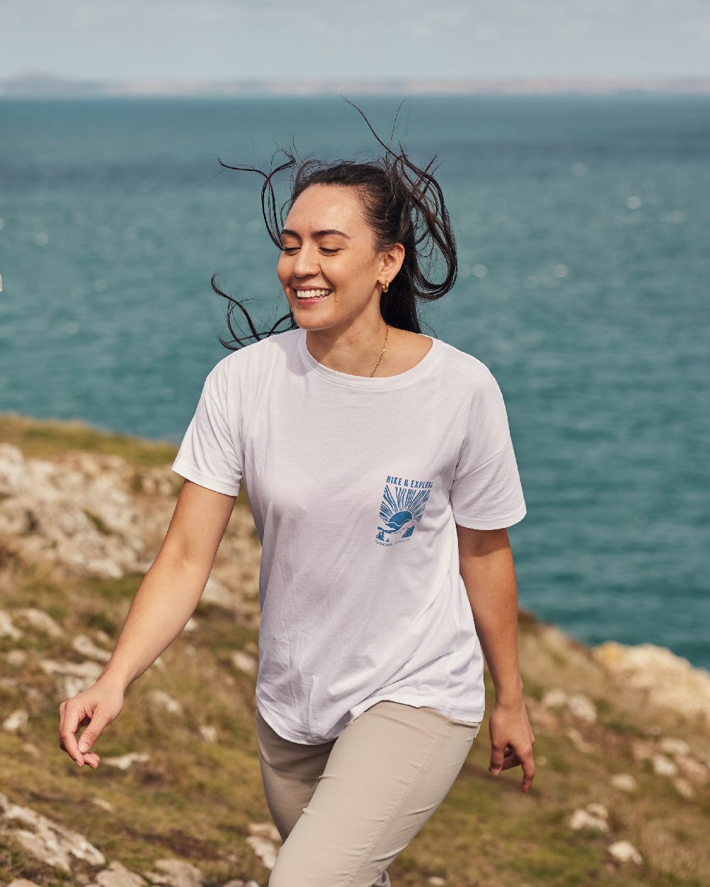 Sea Salt coloured Craghoppers Womens National Trust Bistort Short Sleeved T-Shirt on coastal background