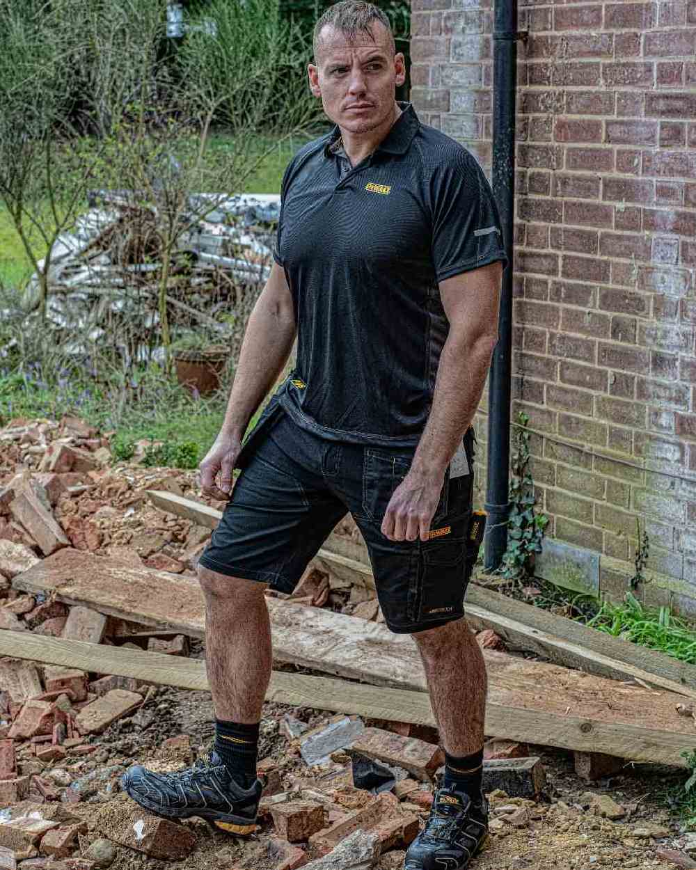 Black Coloured DeWalt Rutland Performance Polo Shirt on outdoor background
