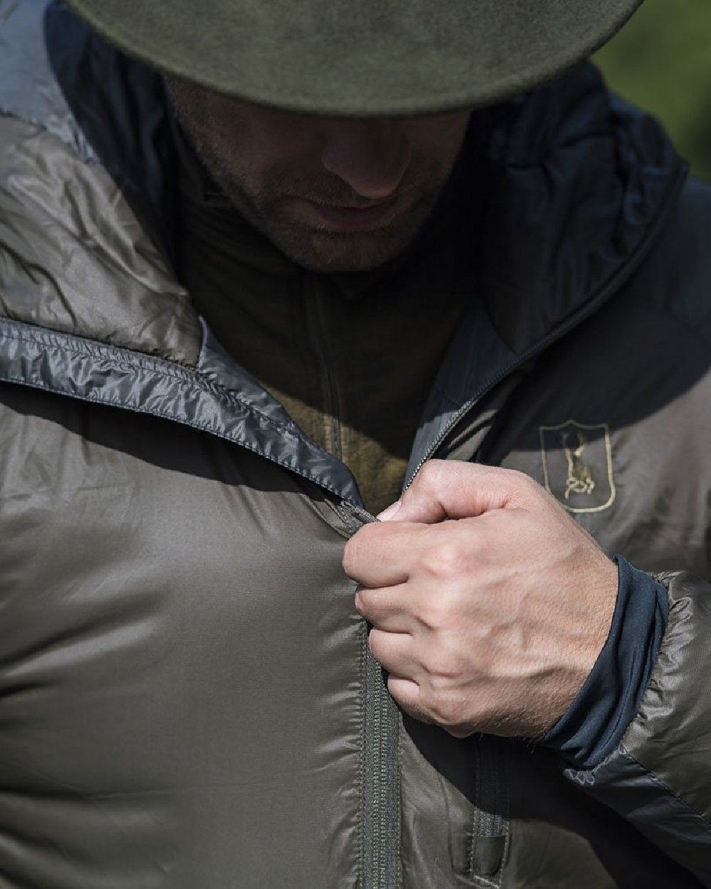 Deep Green Art Green coloured Deerhunter Packable Jacket on blurry background