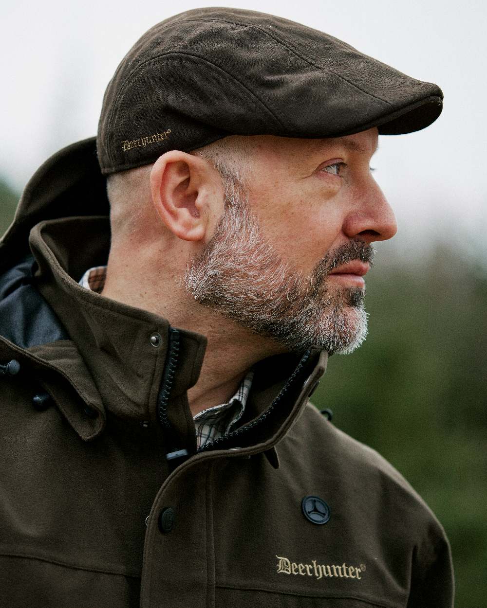 Peat coloured Deerhunter Pro Gamekeeper Flatcap on blurry background