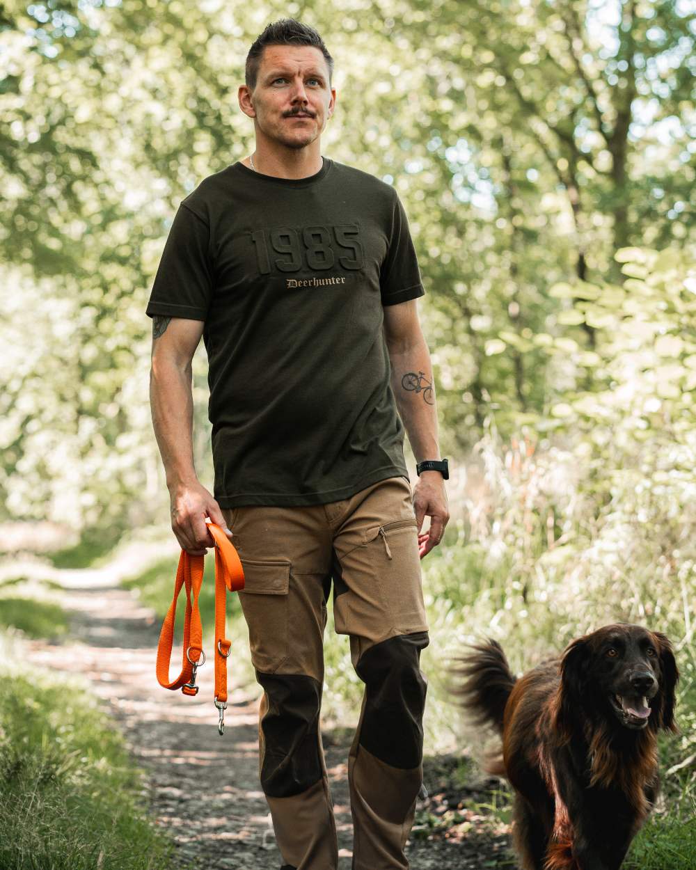 Butternut Fallen Leaf Black coloured Deerhunter Sarek Full Stretch Trousers on forest background