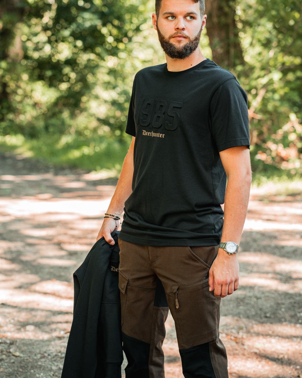Fallen Leaf Black coloured Deerhunter Sarek Full Stretch Trousers on forest background