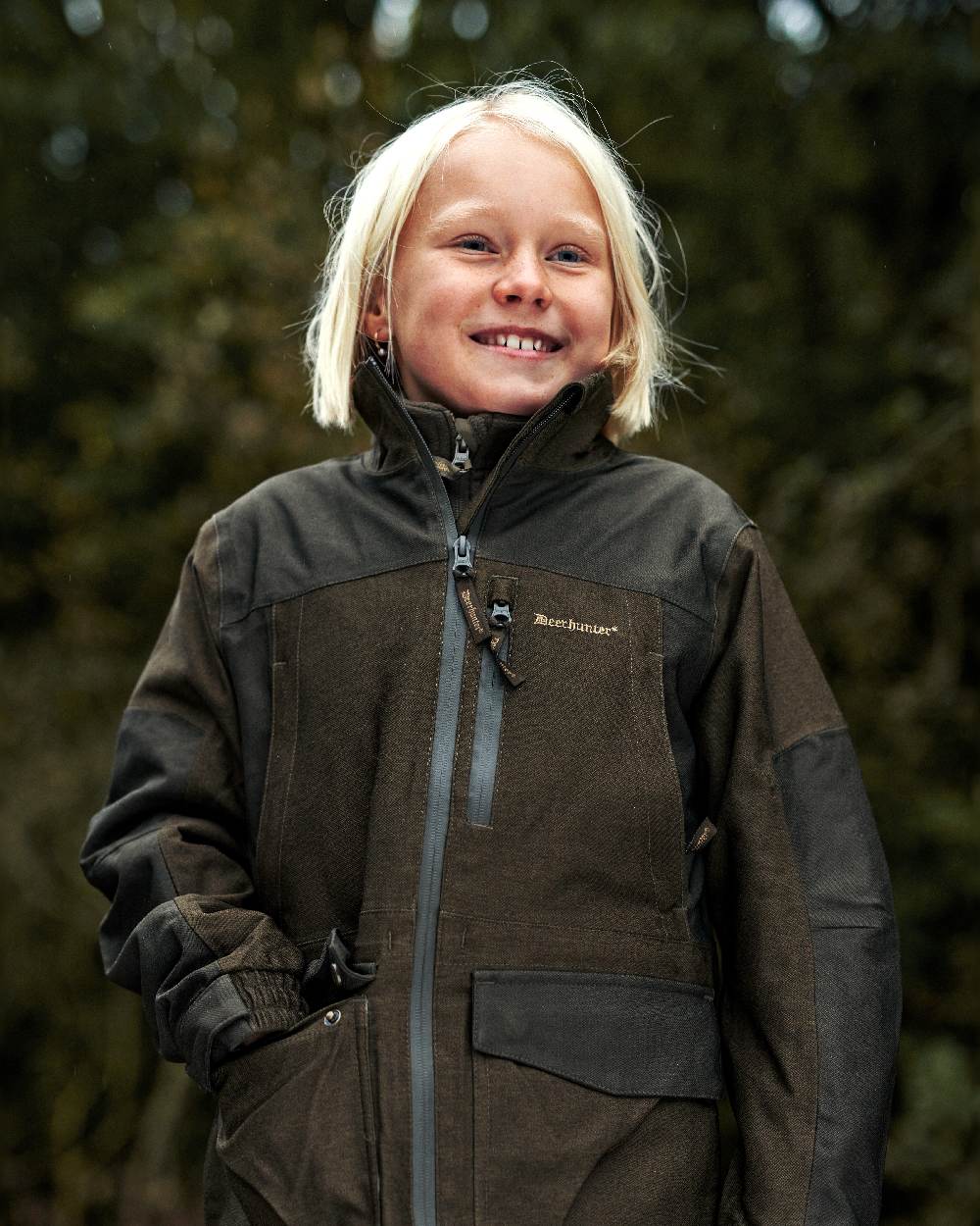Olive Night Melange coloured Deerhunter Youth Chasse Jacket on forest background