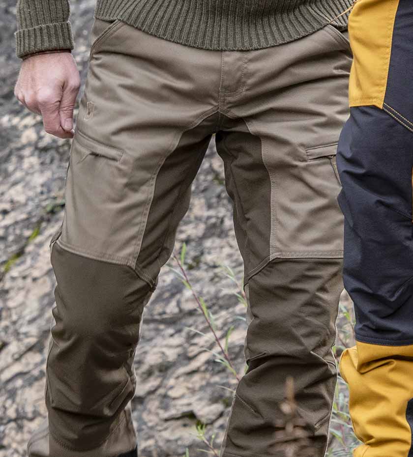 Deerhunter trousers \ Man wears cargo shooting trousers in khaki green.