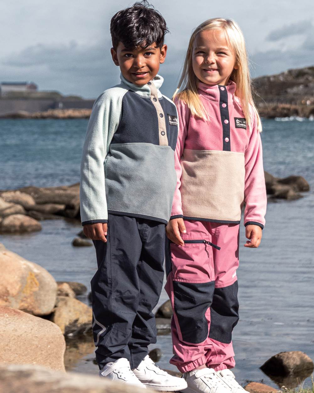 Navy coloured Didriksons Childrens Avan Pants 2 on sea background