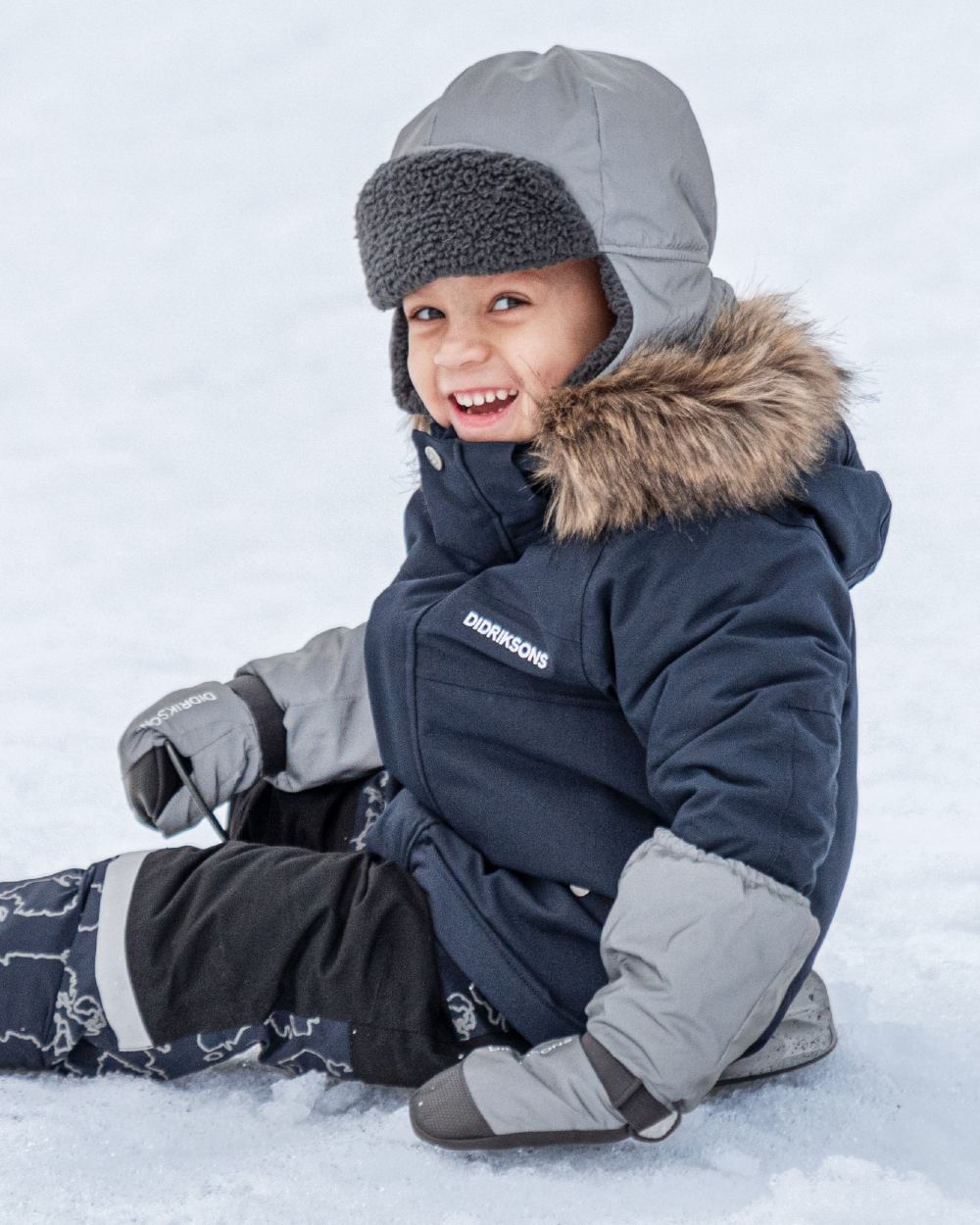 Silver coloured Didriksons Childrens Biggles Reflection Mittens on ice background