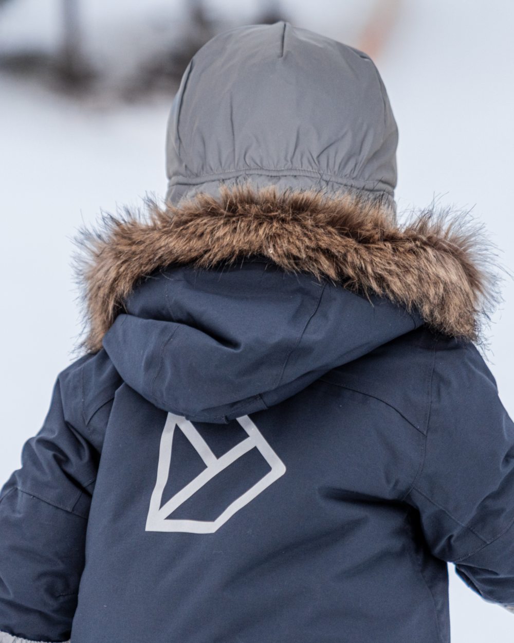 Silver coloured Didriksons Childrens Biggles Reflective Cap on snow background