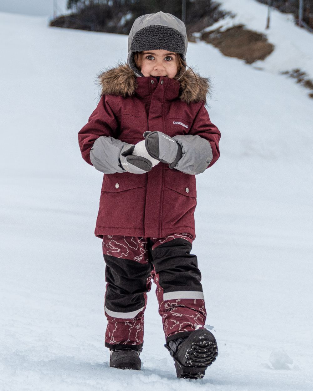 Silver coloured Didriksons Childrens Biggles Reflective Cap on snow background