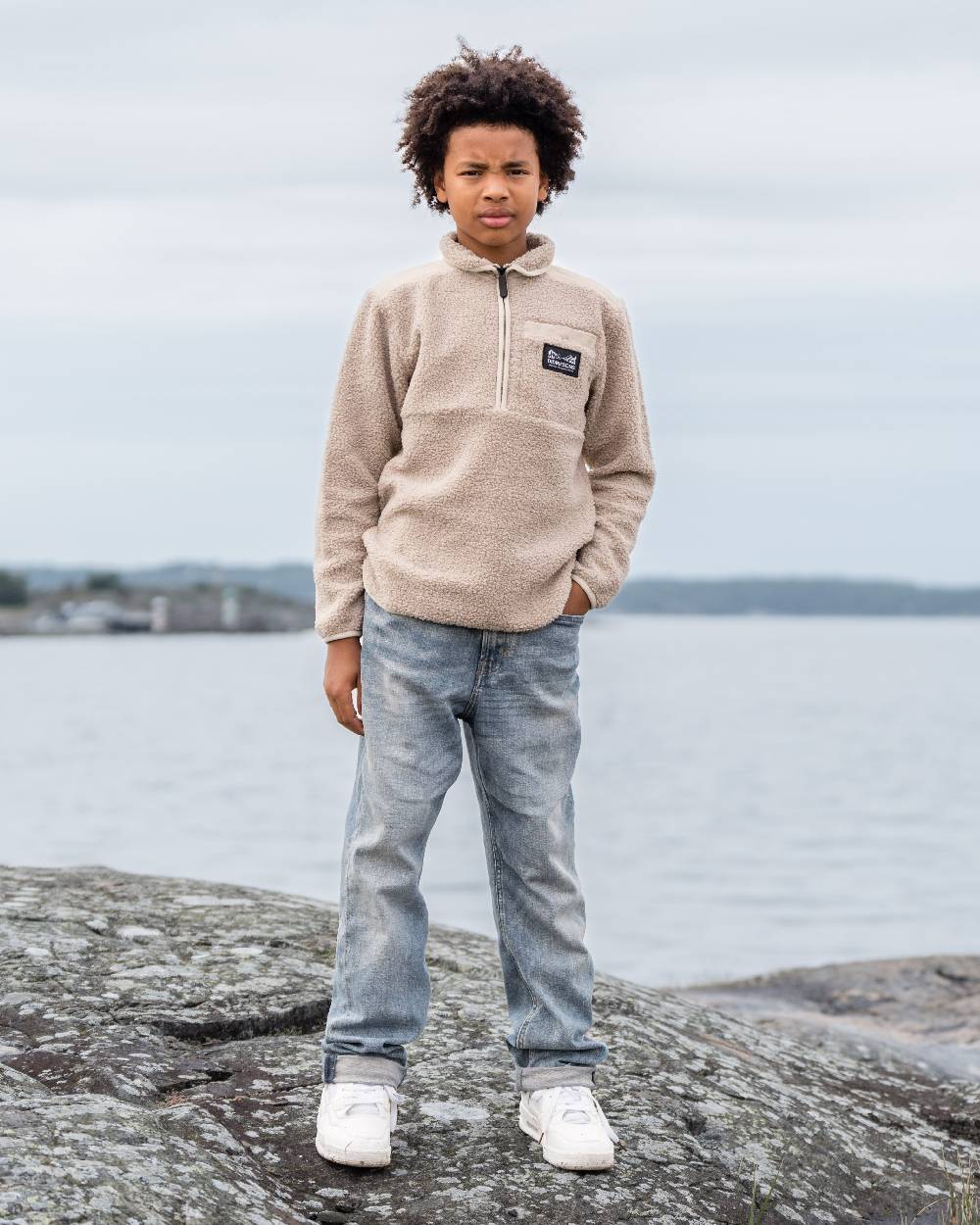 Beach Beige coloured Didriksons Childrens Exa Half Zip Sweater on sea background