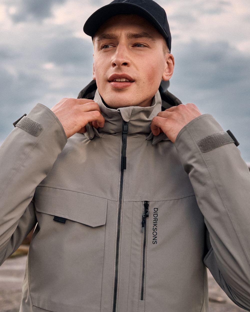 Ash Brown coloured Didriksons Mens Aston Waterproof Jacket on sea background