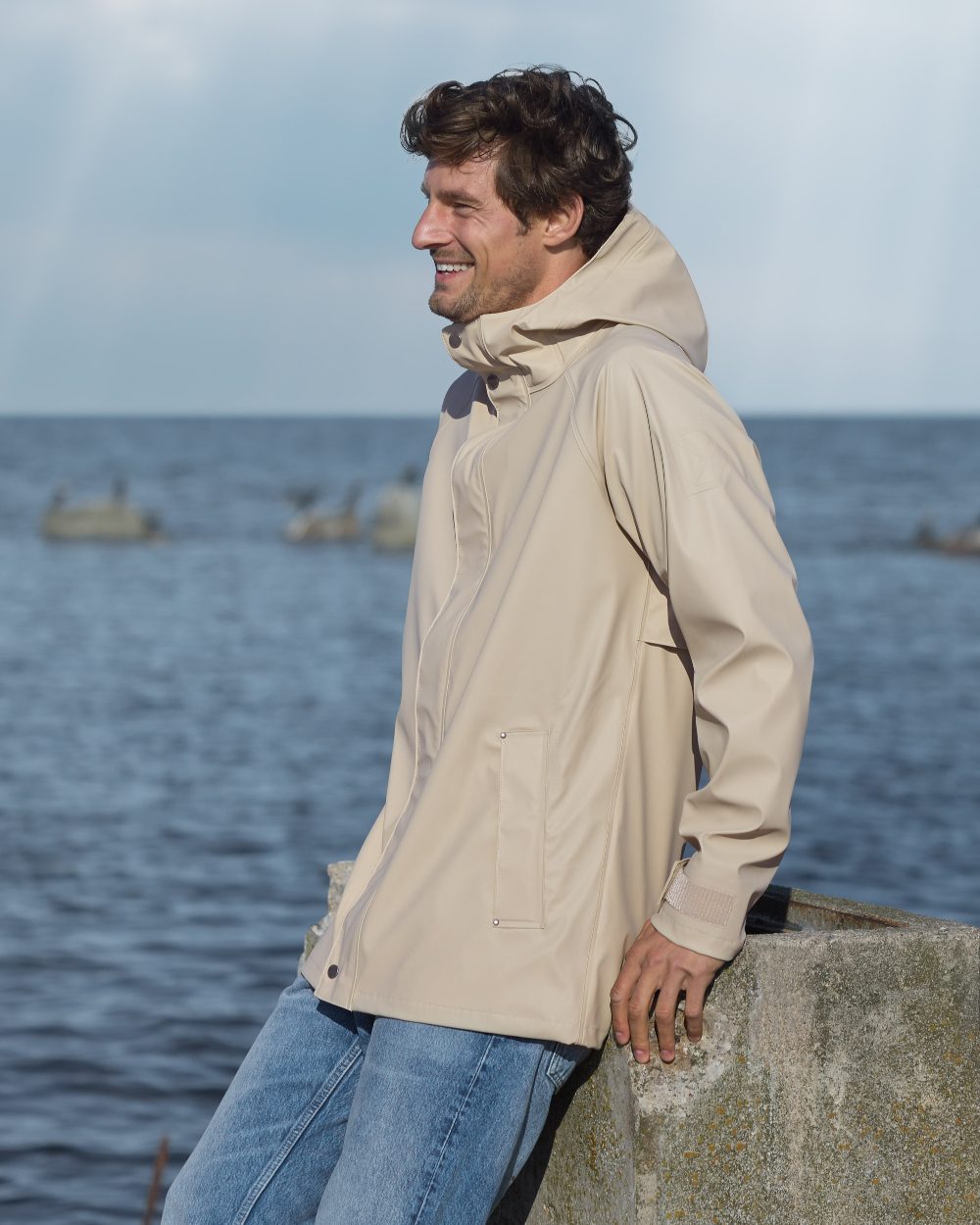 Clay Beige coloured Didriksons Mens Darwin Jacket on sea background