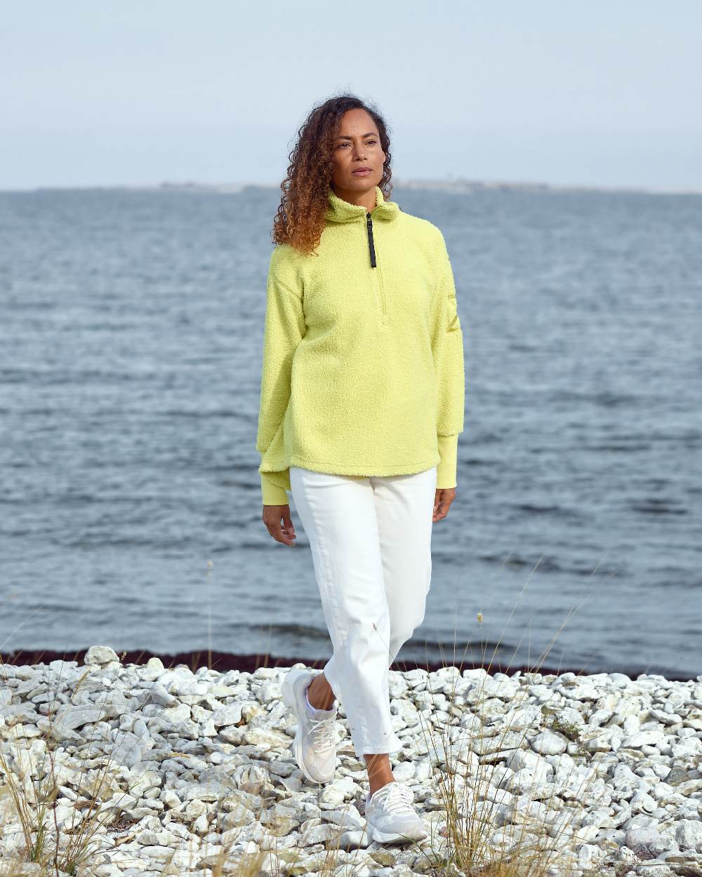 Light Avocado coloured Didriksons Womens Monia Half Zip Sweater on coastal background