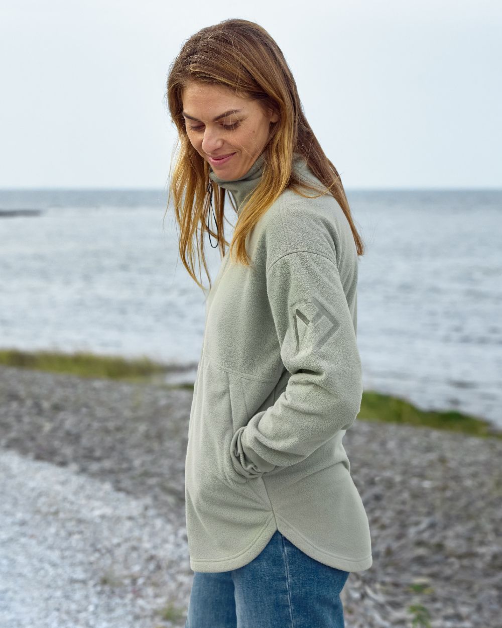 Wilted Leaf coloured Didriksons Womens Ronja Full Zip Sweater on coastal background