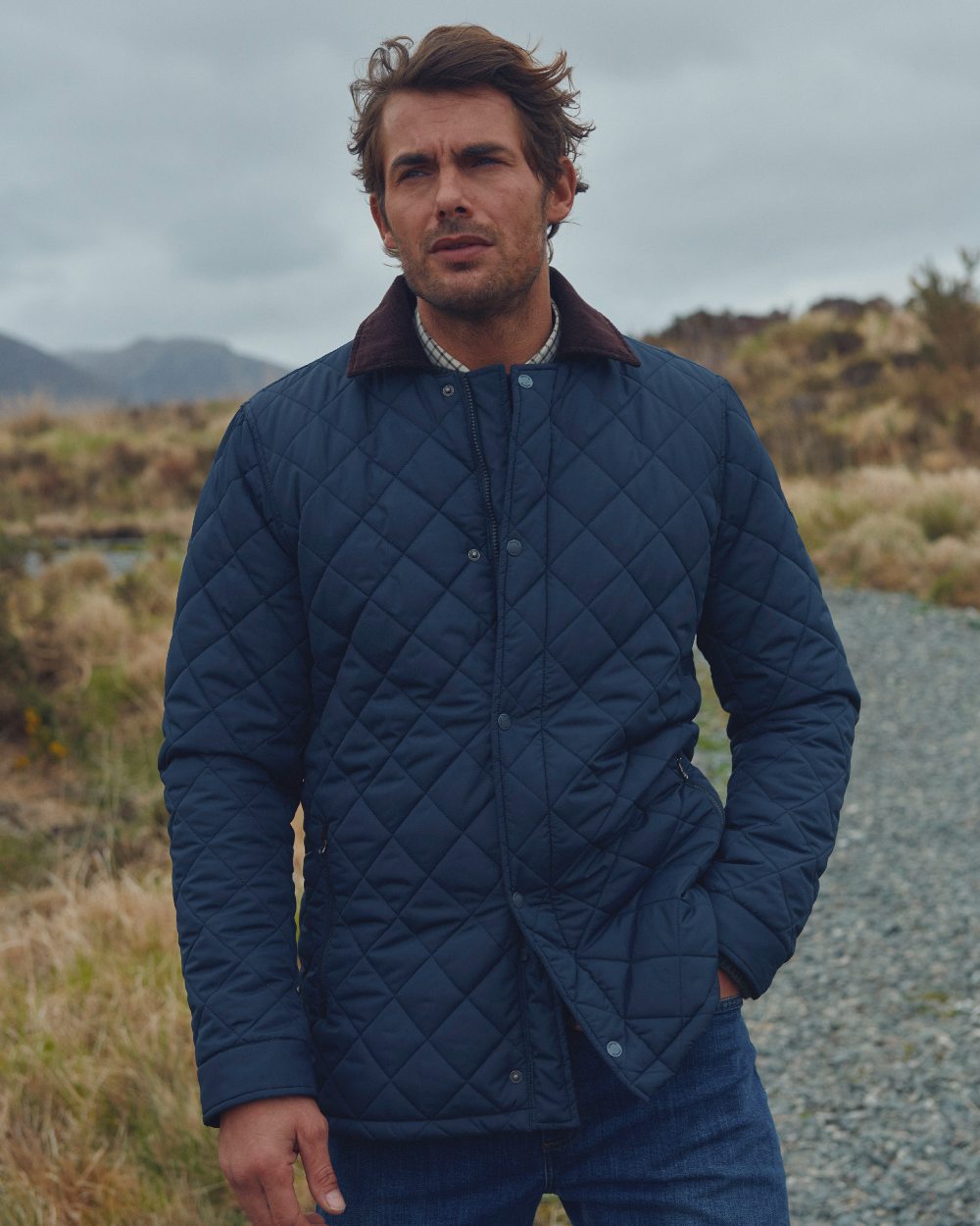 Navy coloured Dubarry Mountusher Quilted Jacket on grass background