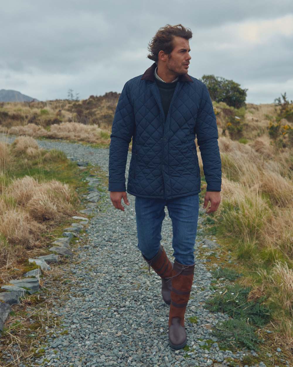 Navy coloured Dubarry Mountusher Quilted Jacket on grass background