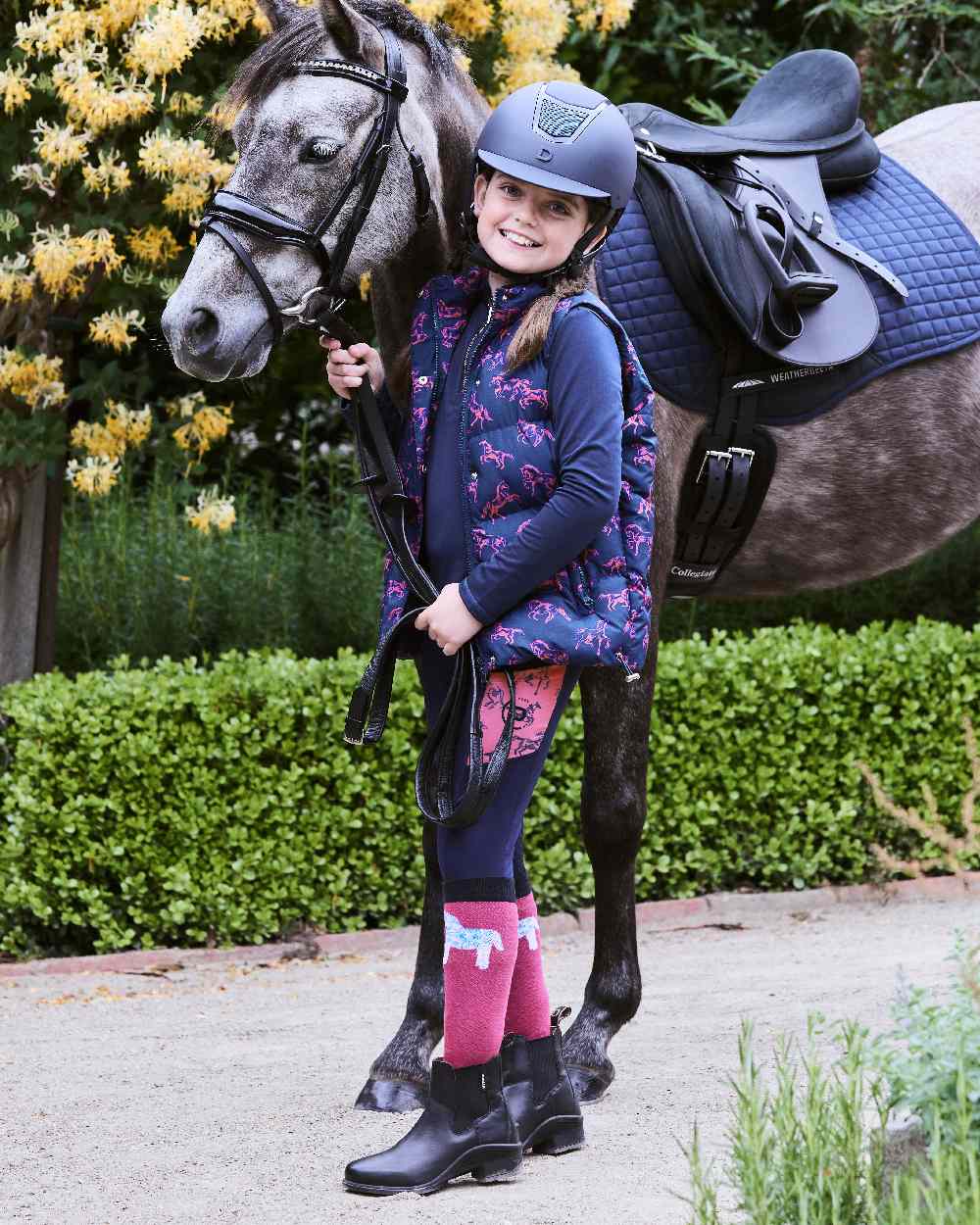Navy Frolicking Horses coloured Dublin Childrens Patrice Everyday Puffer Vest on street background