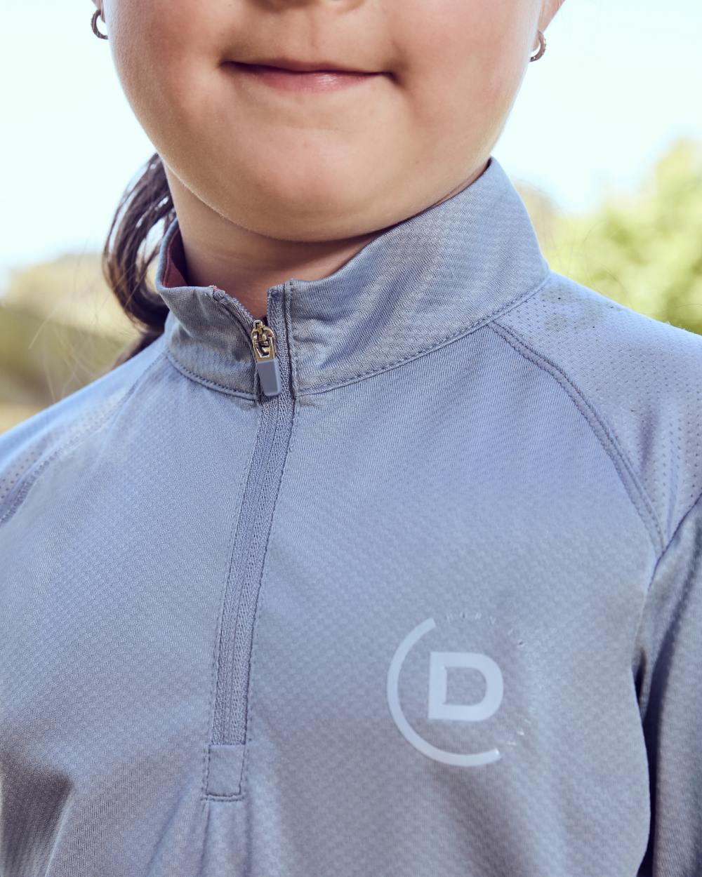 Blue Fog coloured Dublin Kids Breathable Long Sleeve Riding Top on blurry background