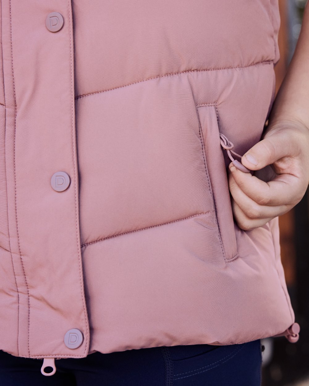 Dusty Rose coloured Dublin Kids Puffer Body Warmer on blurry background