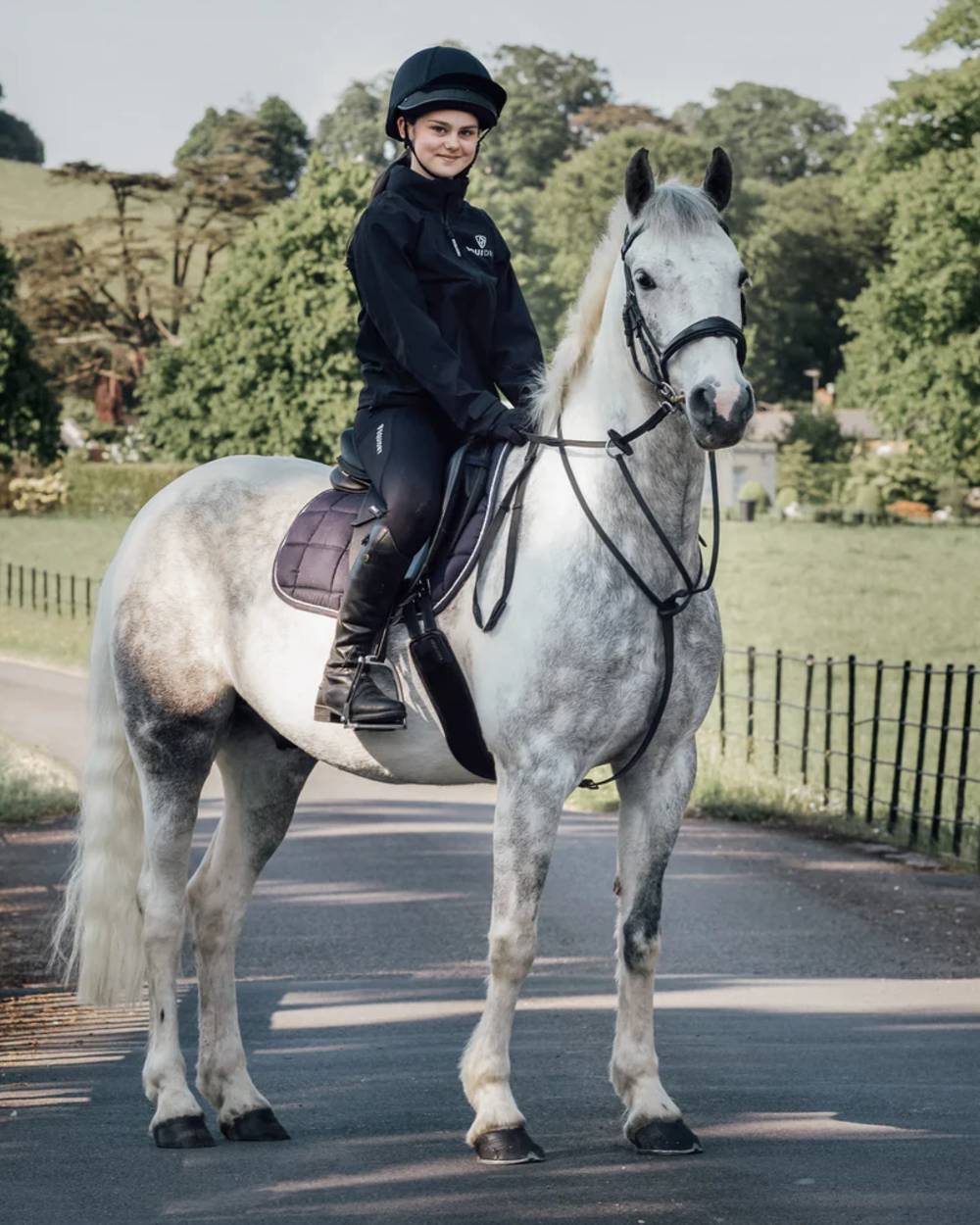 Black coloured Equidry Childrens Nimbus Pack Away Jacket With Stowaway Hood on outdoor background
