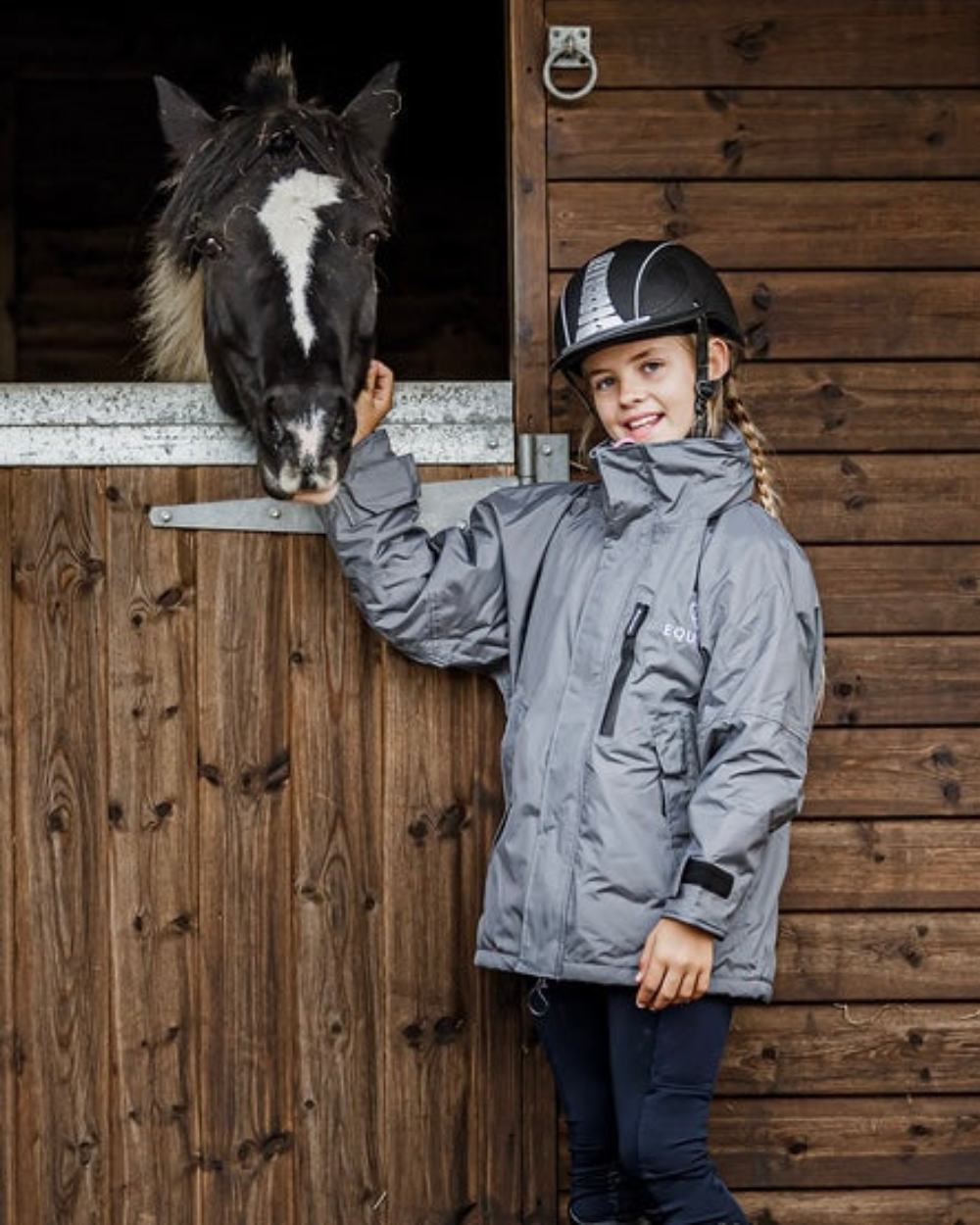 Charcoal Penelope Pink coloured Equidry Childrens Shortie Jacket on stable background